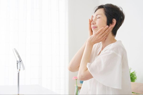 たるみが気になる顔に両手を添えるミドル女性