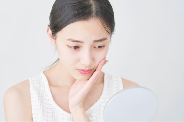 鏡を見て悩む女性