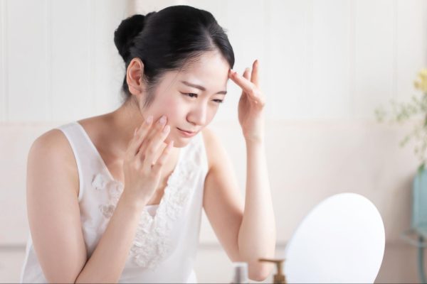たるみを気にして鏡を見ている女性