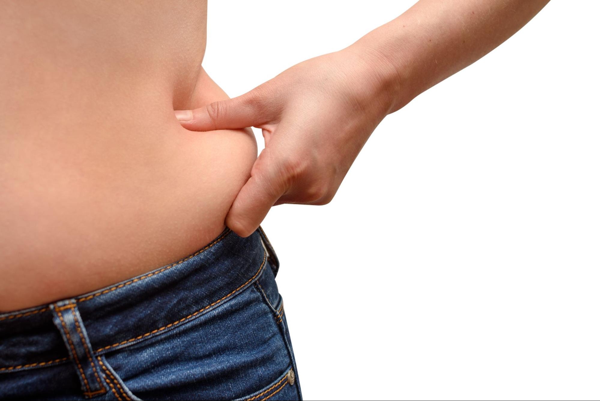 ウエストをつまむ女性