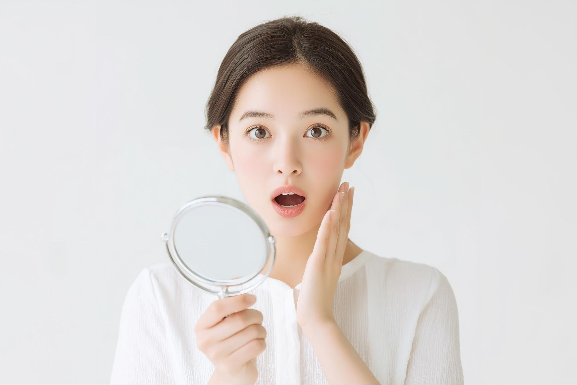 鏡を見ながら驚く女性