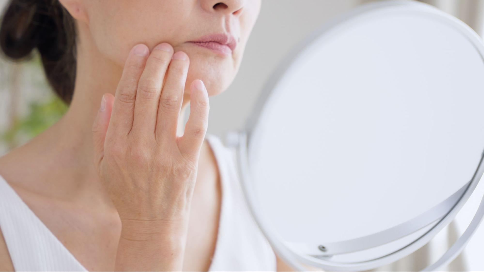 鏡を見ながら悩む女性