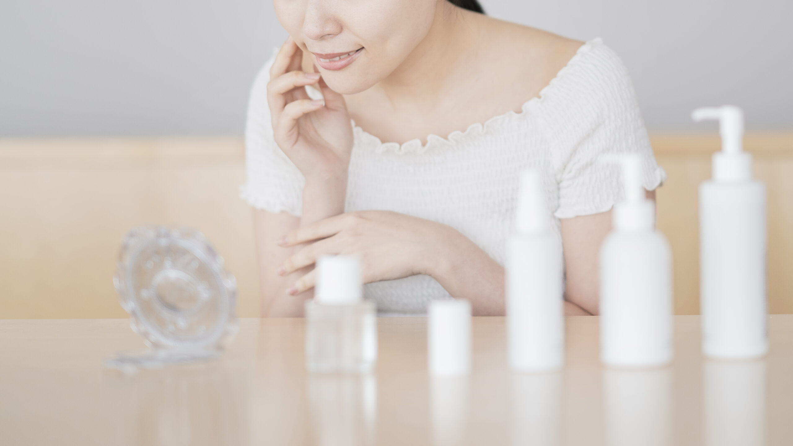 スキンケアをしながら鏡を見ている女性