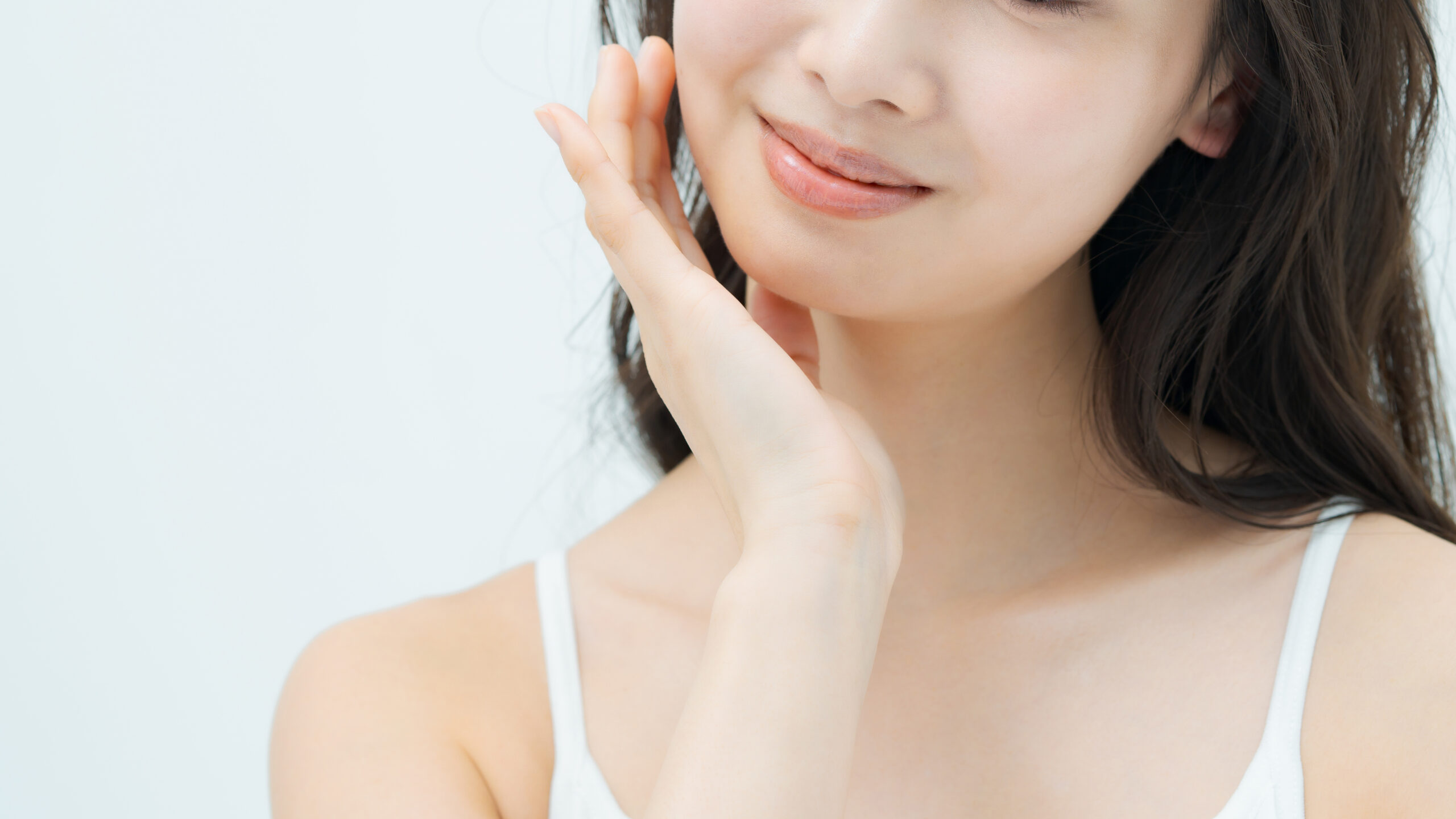 頬に手を当てて微笑んでいる女性