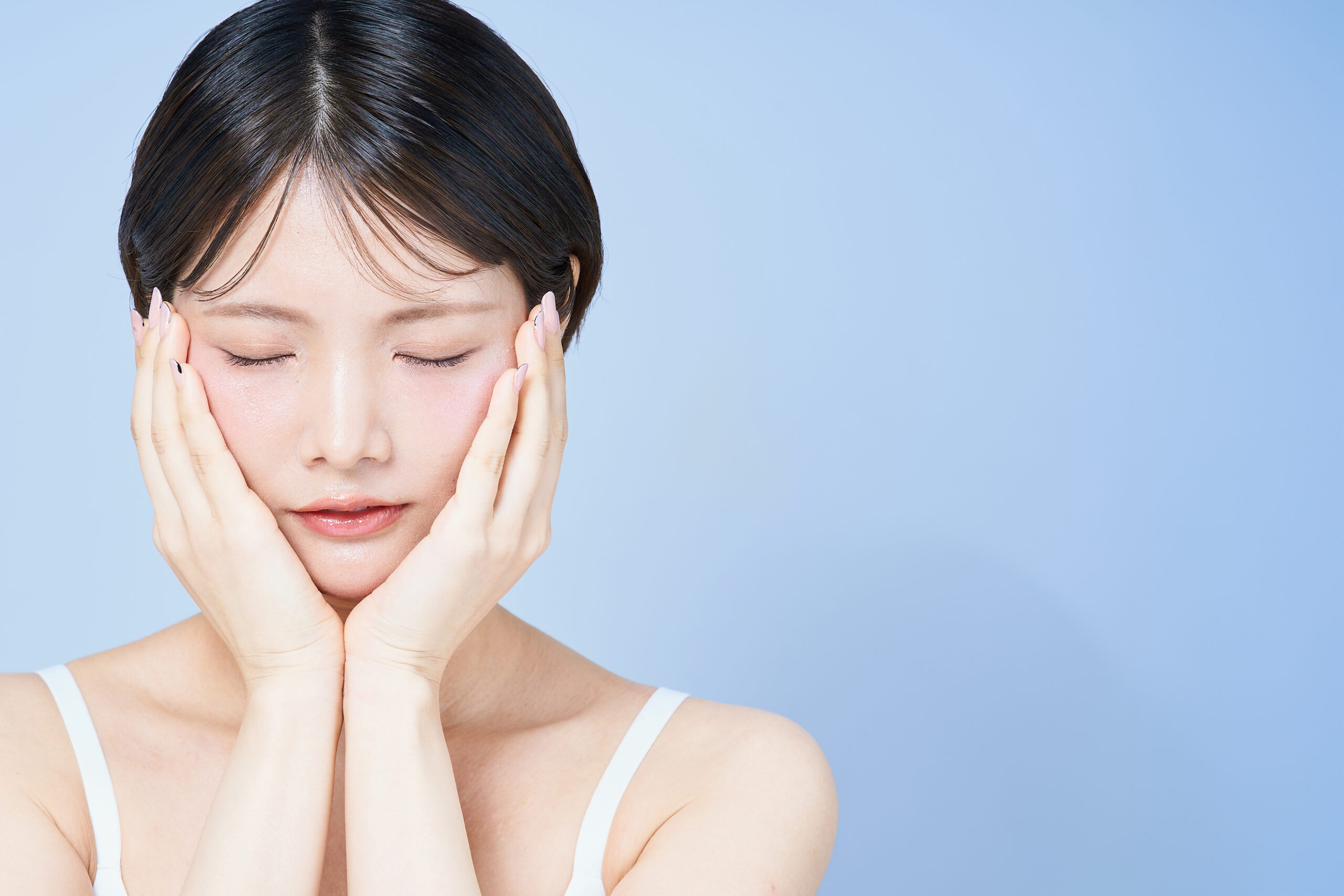 頬を両手で包み込み目を瞑っている女性